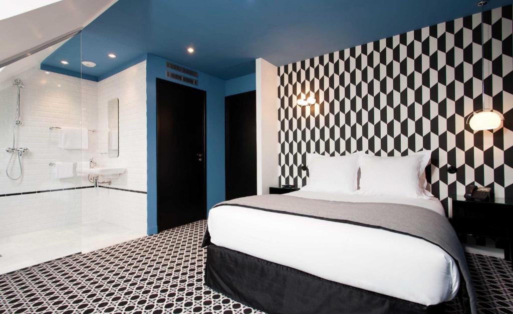 
A bed or beds in a room at Hôtel Emile
