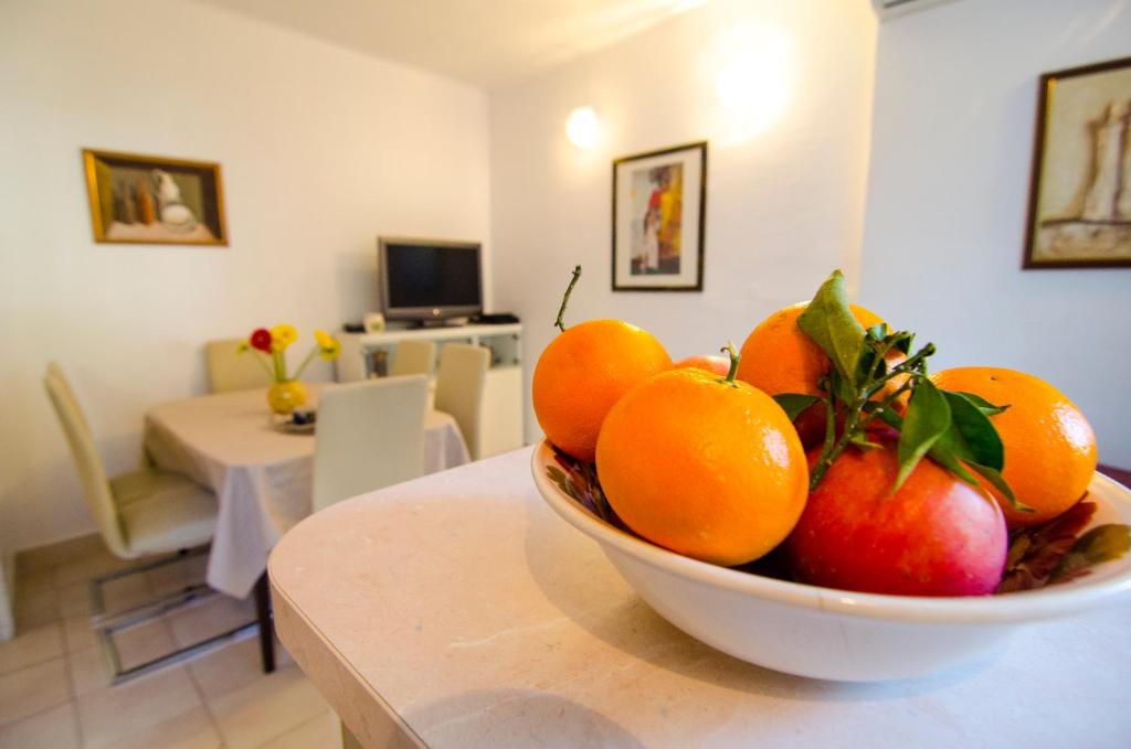 a bowl of oranges and apples on a table at Apartment Sugar Flat in Split