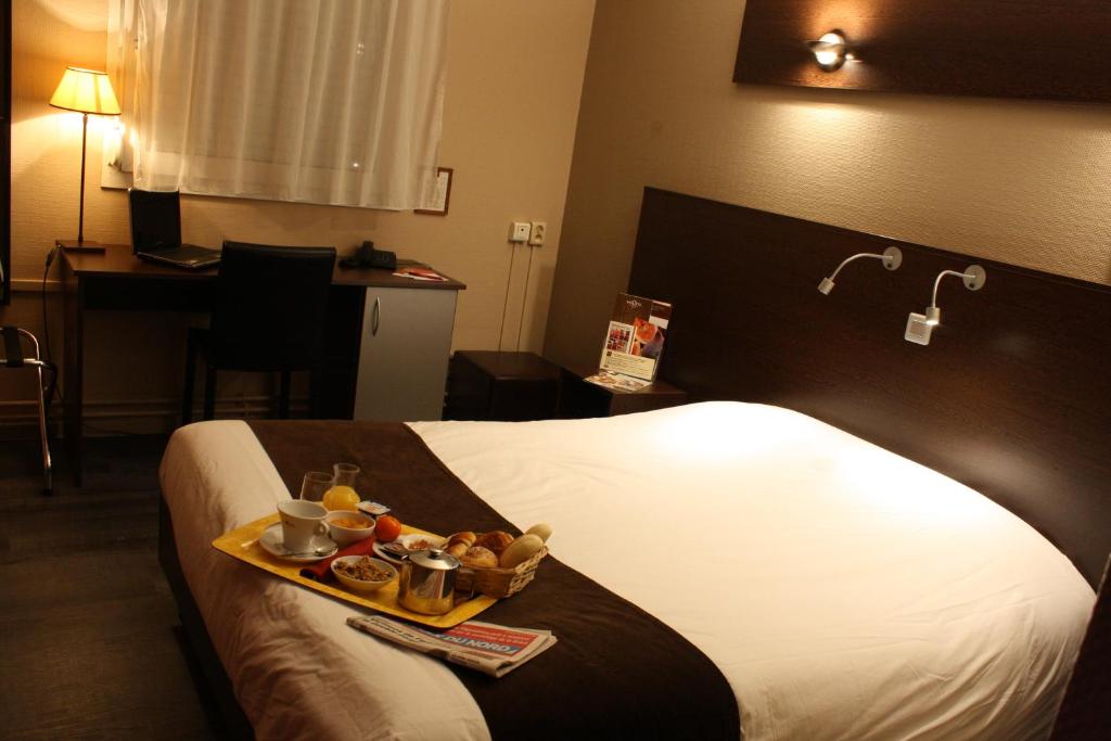 bandeja de comida en una cama en una habitación de hotel en The Originals City, Hôtel Ascotel, Lille Est Grand Stade (Inter-Hotel) en Villeneuve d'Ascq