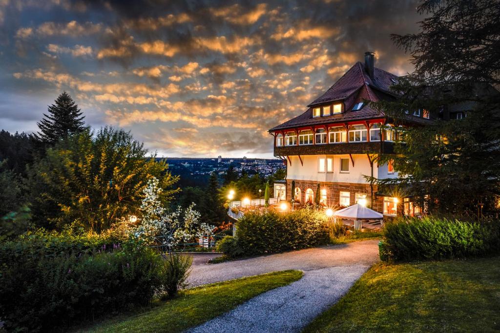 フロイデンシュタットにあるホテル トイヒェルヴァルトの夜にライトアップされる大きな家