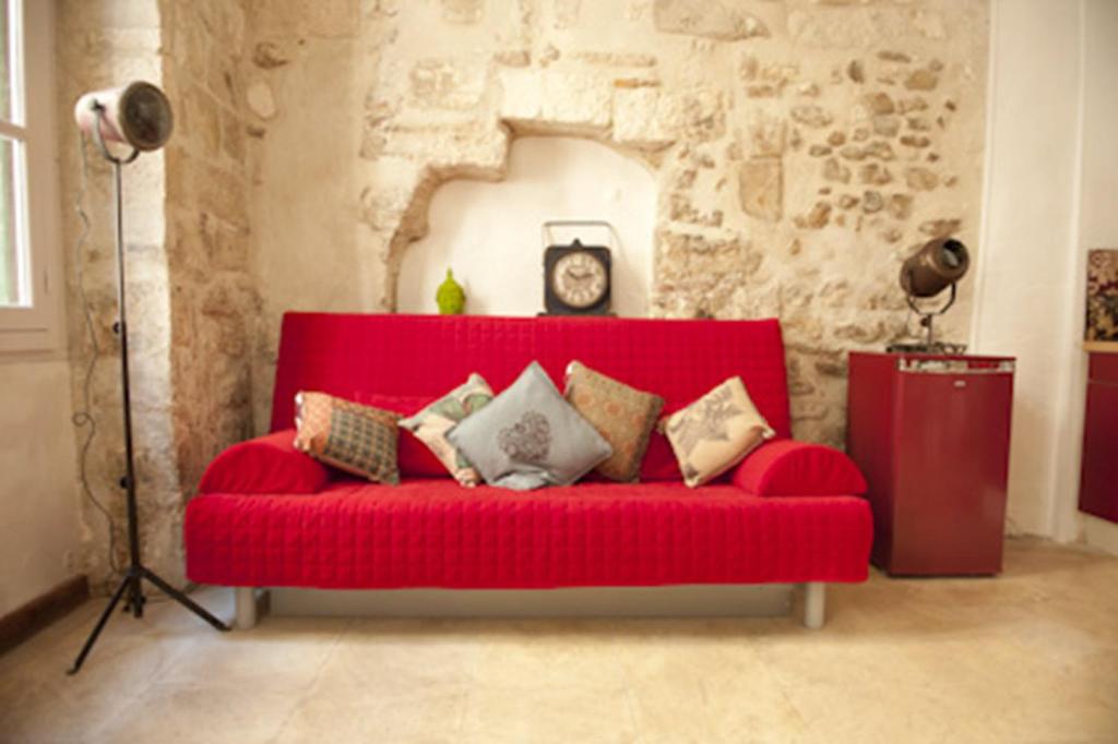 アヴィニョンにあるCité des Papesの赤いソファ(枕付)が備わるリビングルーム