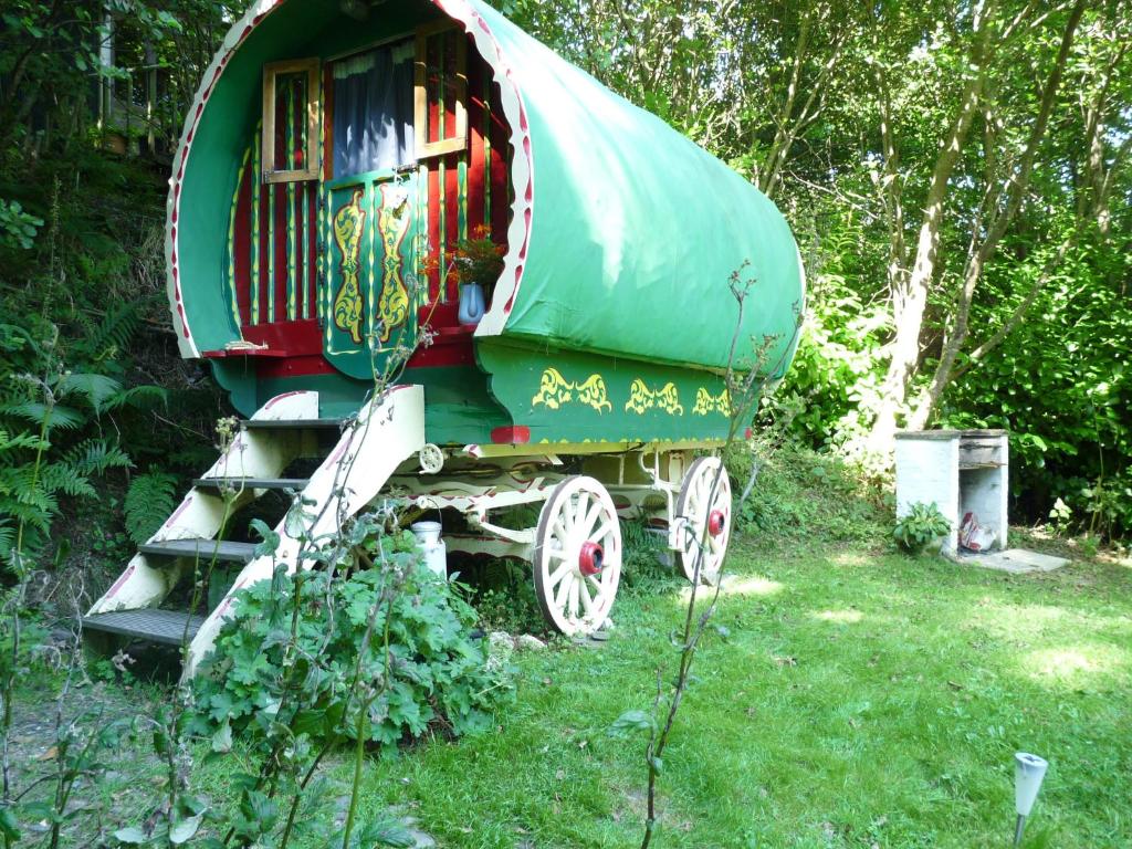 a green and red train car sitting in the grass at Romany Wagon & Cwtch in Llandysul