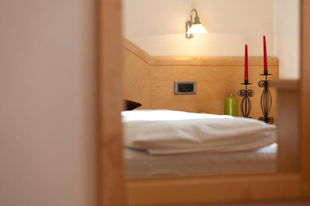 odbicie sypialni z łóżkiem w lustrze w obiekcie Appartement Huber w mieście Brunico