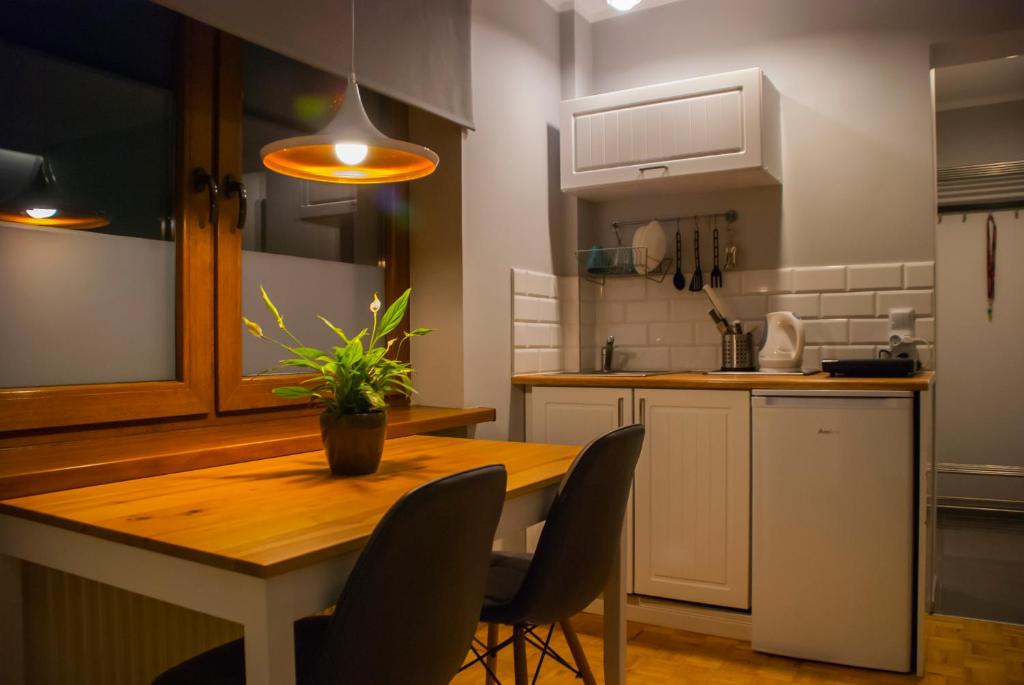 cocina con mesa de madera y sillas en Apartamenty Akacjowa przy Parku Szwedzkim, en Szczawno-Zdrój