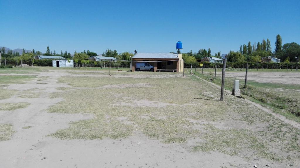 un campo vacío con un edificio en el fondo en Cabaña Anfuso en San Rafael