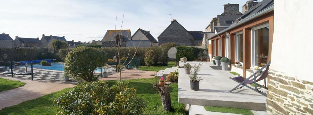 a house with a yard with a chair and a pool at La Grande Mare in Saint-Benoît-des-Ondes