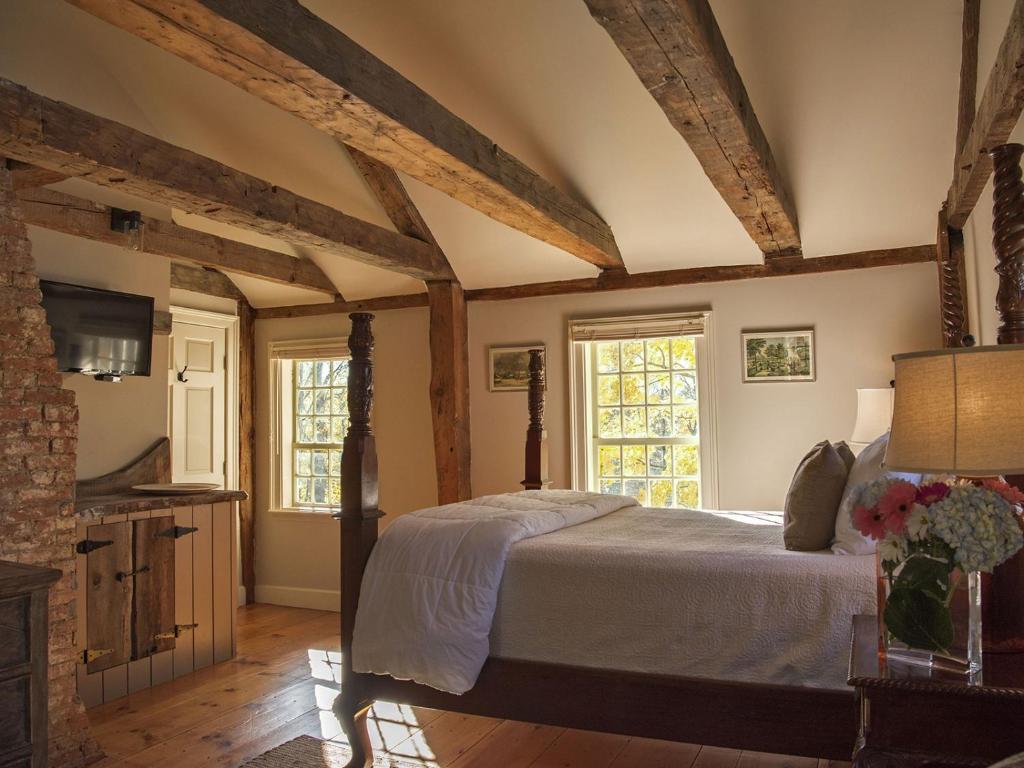 una camera con letto in una stanza con travi in legno di Three Chimneys Inn a Durham