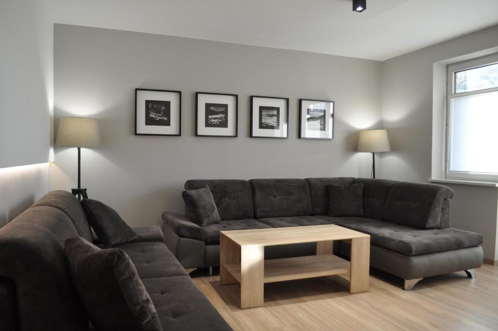 a living room with a couch and a coffee table at Apartament Cynamon ,Wanilia i Goździk in Szczawnica