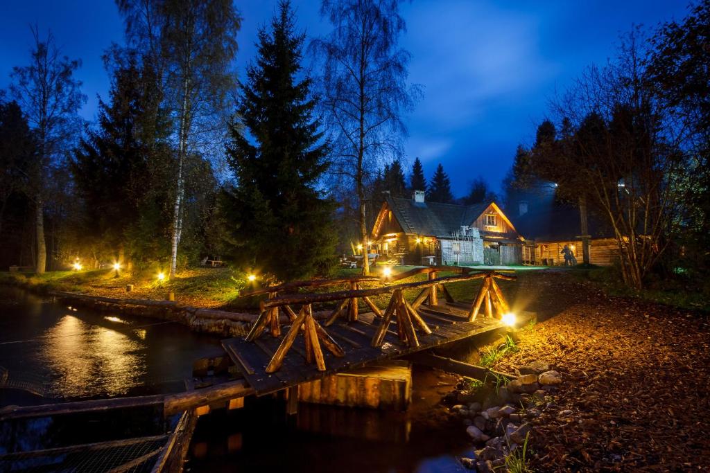 a wooden bridge over a river at night at Viikingite küla in Saula