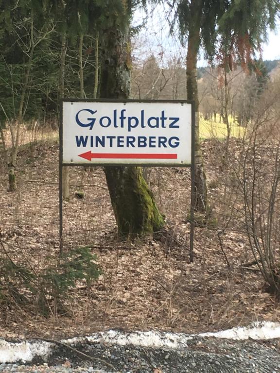 a sign on the side of a road next to a tree at Am Golfplatz 800 Meter bis Möppis Hütte in Winterberg
