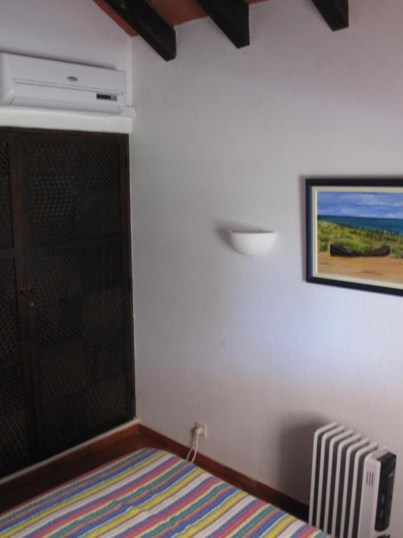 a bedroom with a door and a painting on the wall at Villa Sofia in Tavira