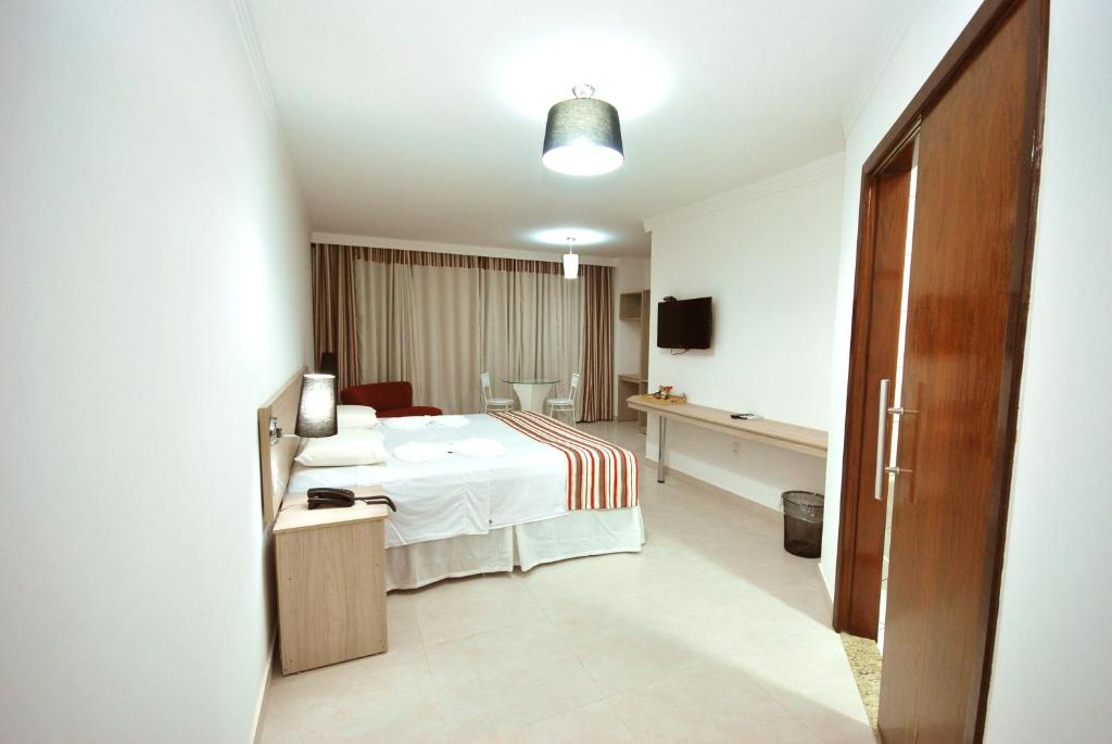 a hotel room with a bed and a television at Parati Palace Hotel in Santo Antônio de Jesus