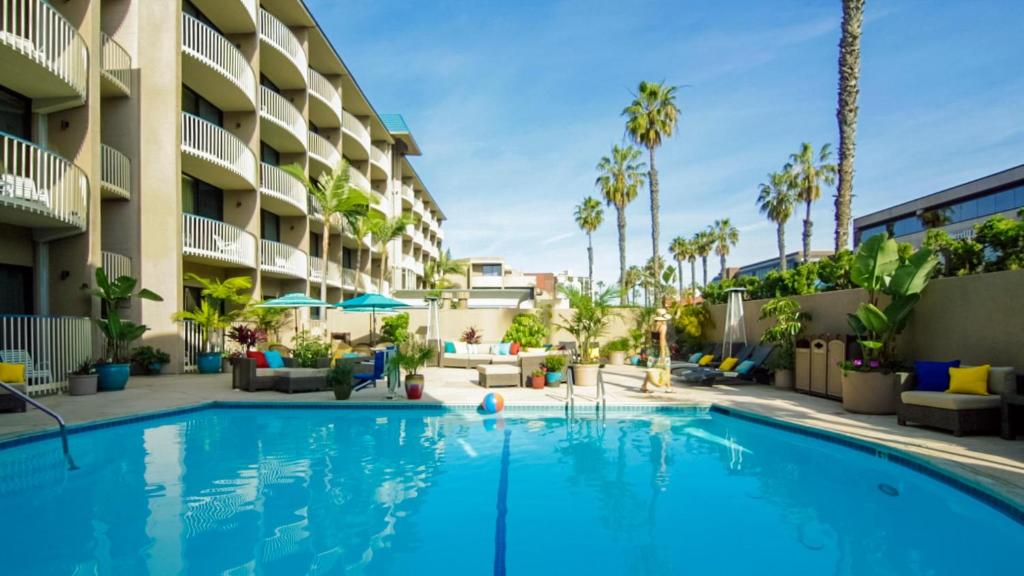 a swimming pool in front of a hotel with palm trees at Inn by the Sea, La Jolla in San Diego