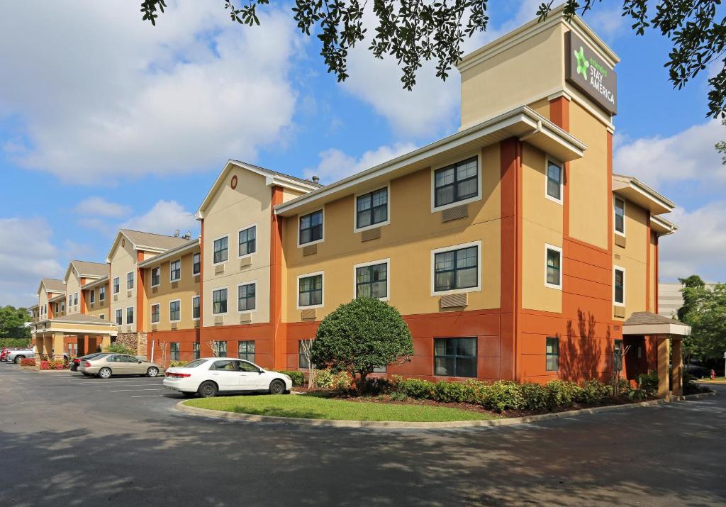 a hotel building with a car parked in a parking lot at Extended Stay America Suites - Orlando - Convention Ctr - Sports Complex in Orlando