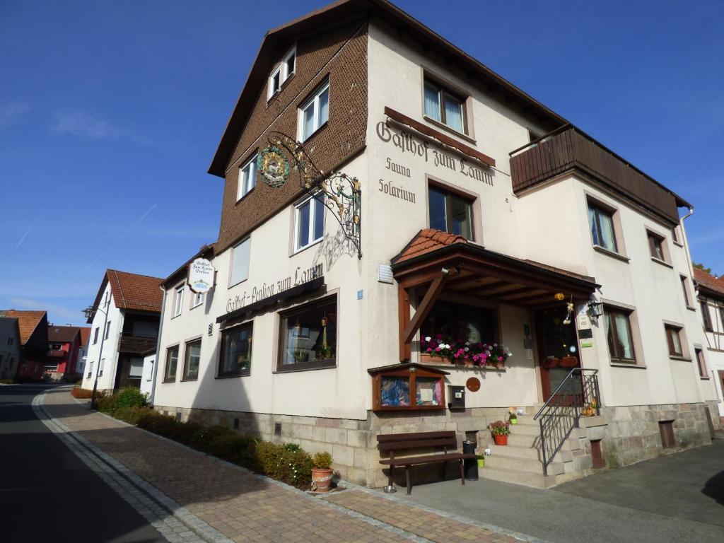 ein großes weißes Gebäude mit einer Uhr drauf in der Unterkunft Pension Gasthof Zum Lamm in Bischofsheim an der Rhön