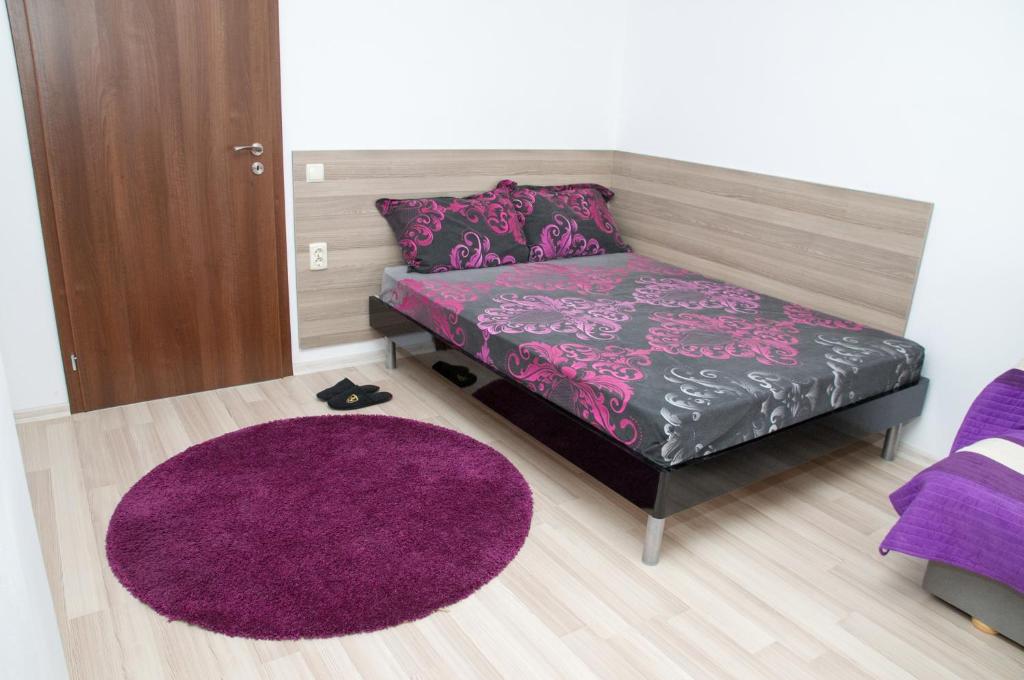 a bedroom with a purple bed and a purple rug at Apartment Medical University in Pleven