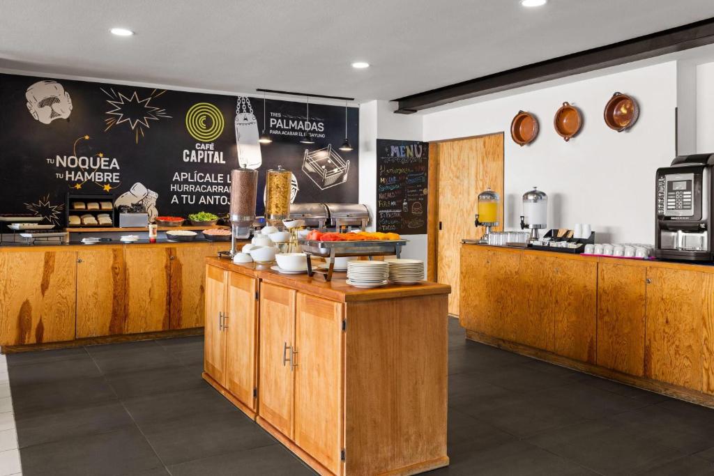 A self-service breakfast counter displays coffee, drinks, plates, and prepared food.