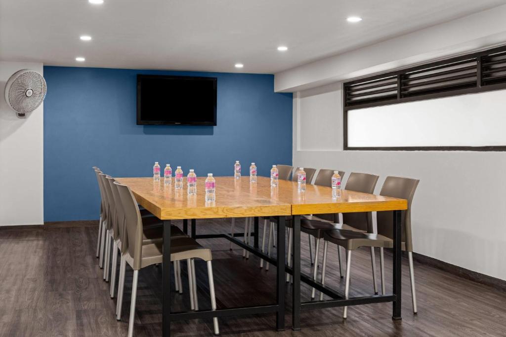 A private meeting room with a long table, chairs and bottled water.
