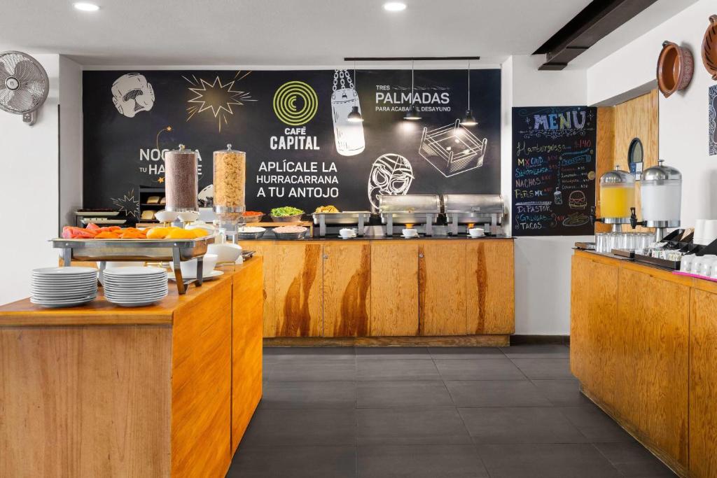 A self-service breakfast counter with plates, dispensers and prepared food.