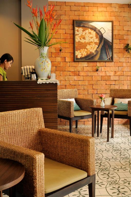 a woman sitting in a restaurant with a pizza on the wall at Kasemsarn Hotel Chanthaburi in Chanthaburi