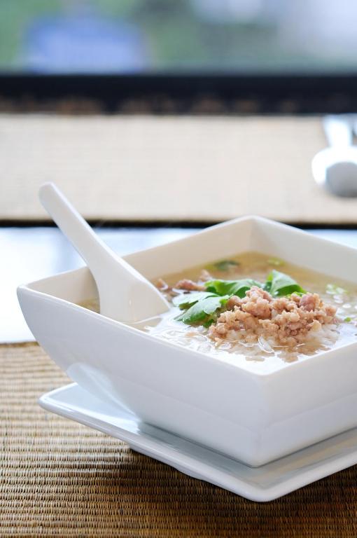 a bowl of soup with a spoon on a table at Kasemsarn Hotel Chanthaburi in Chanthaburi