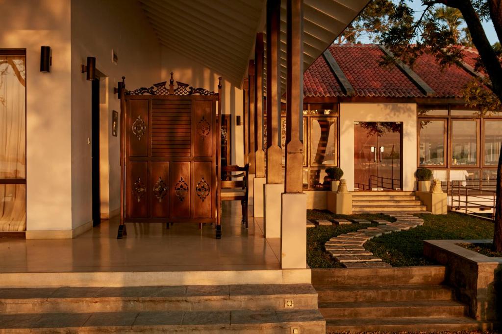 a front porch of a house with a wooden door at EKHO Lake House in Polonnaruwa