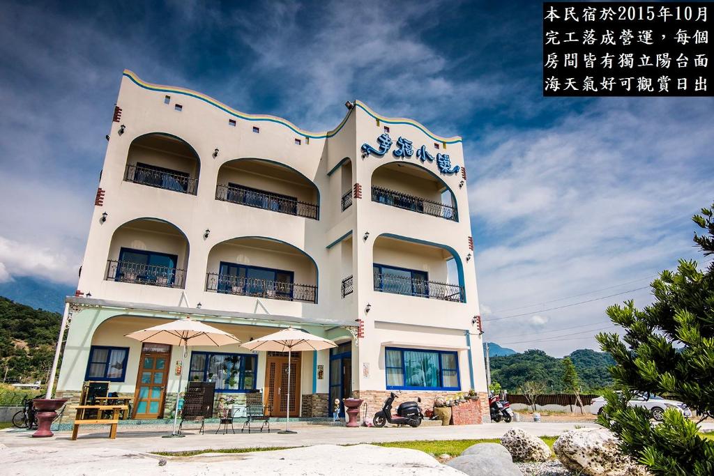 a white building with an oriental writing on it at Happiness House B&B in Chenggong