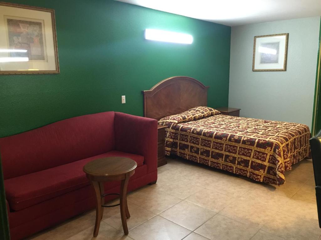a hotel room with a bed and a couch at Texas Inn in Brownsville