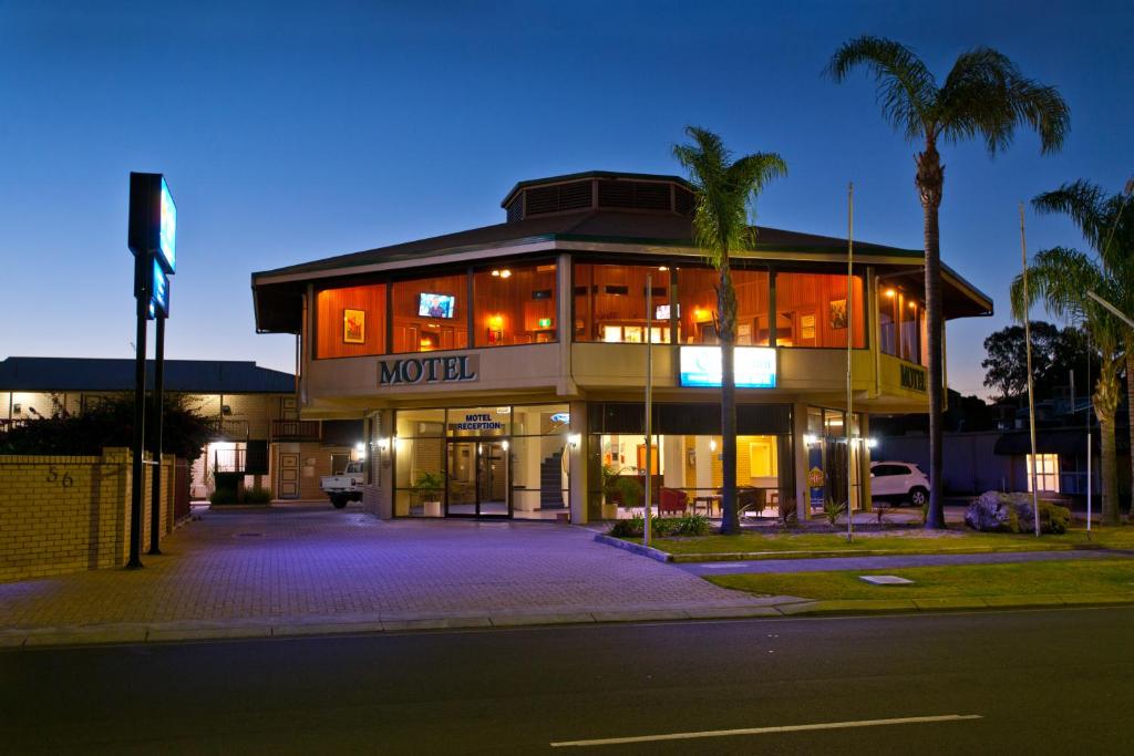 a building on the corner of a street at night at Admiral Motel Bunbury in Bunbury