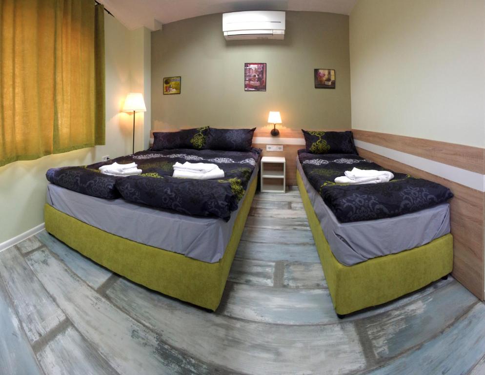 2 camas en una habitación con sofá y mesa en Guest House "The House" Топ Център Габрово, en Gabrovo