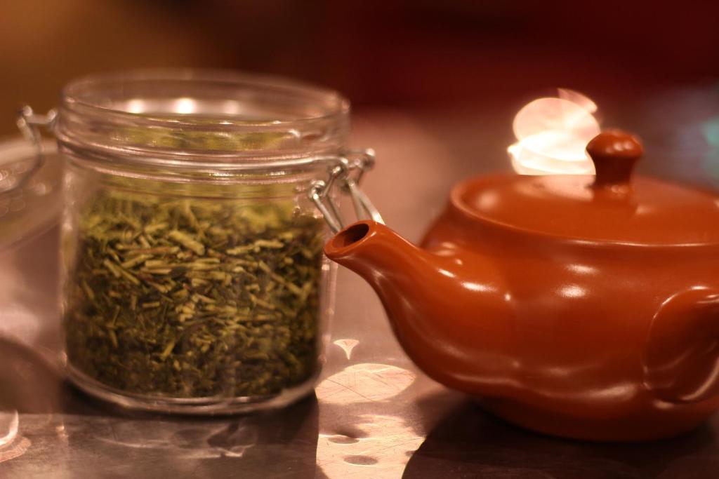 a jar of green beans next to a teapot at Guest House MARUYA in Atami