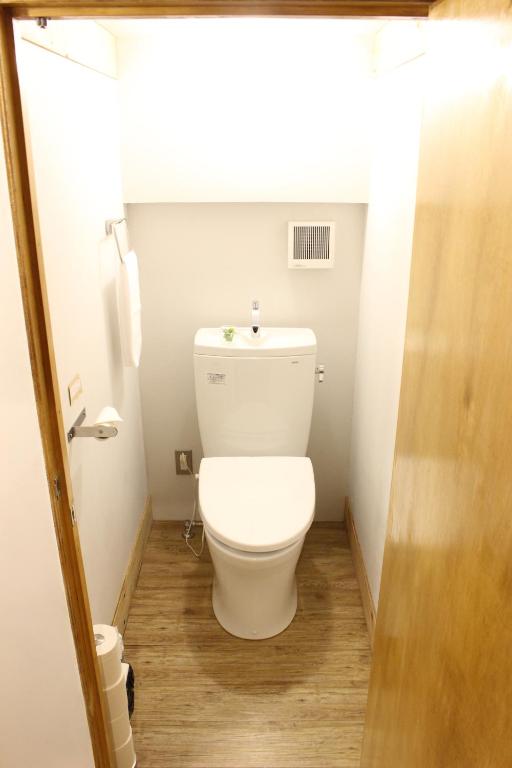 a bathroom with a white toilet in a room at Guest House MARUYA in Atami