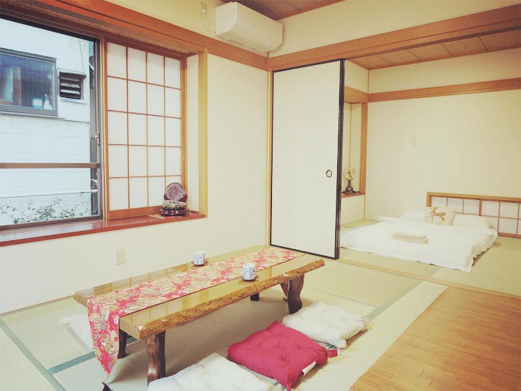 a room with a table and a room with a bed at Kiki HouseH --Self Check-in -- Room Number & Password is in the following email in Tokyo