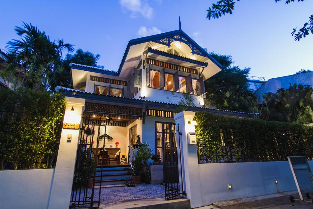 una casa blanca con una puerta por la noche en Baan Noppawong en Bangkok