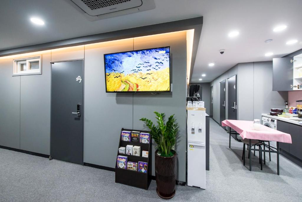 a kitchen with a tv hanging on a wall at Philstay Myeongdong Metro in Seoul