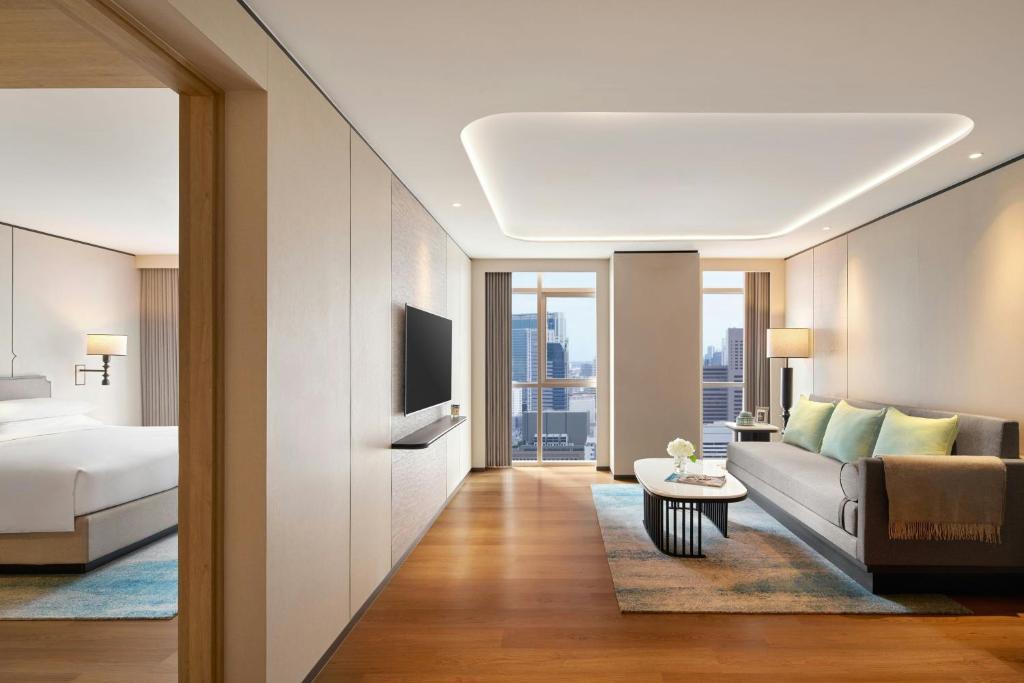 A suite-style sitting room with a sofa, coffee table and adjoining bedroom.