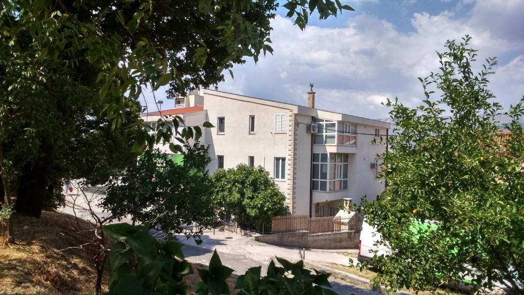 um edifício branco com árvores em frente em Swiss Holiday em Split