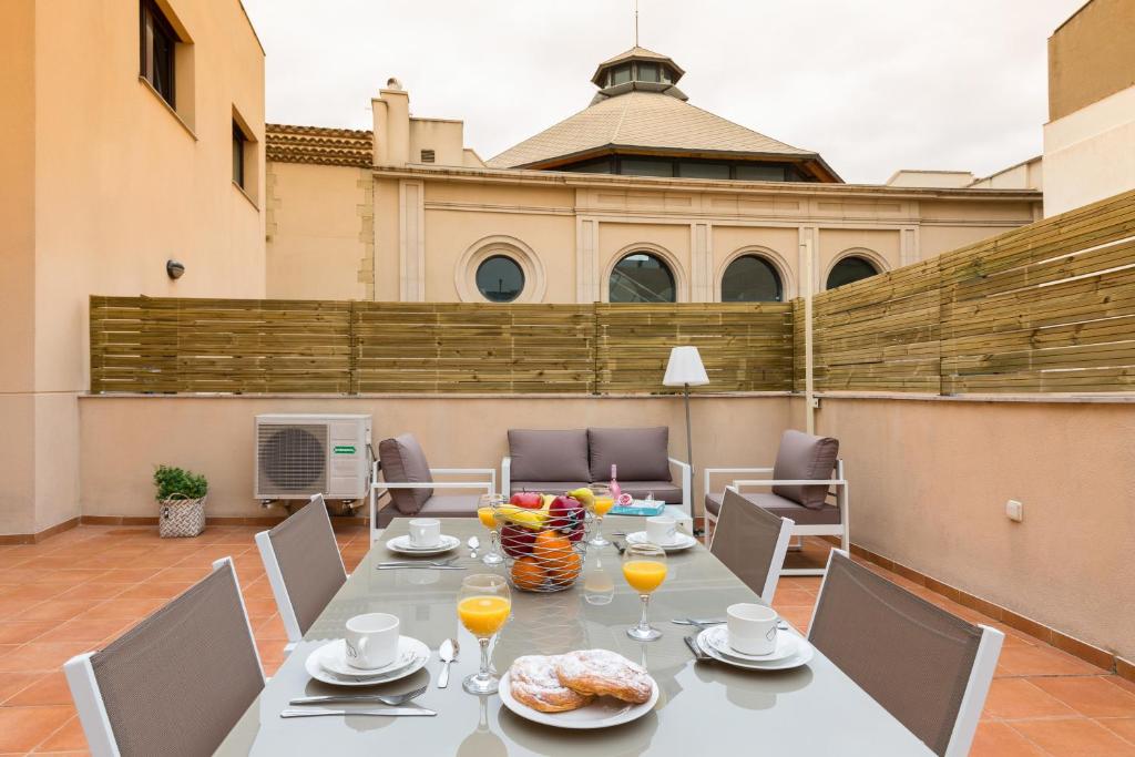 a table with food and drinks on a patio at Matarolux 8 in Mataró