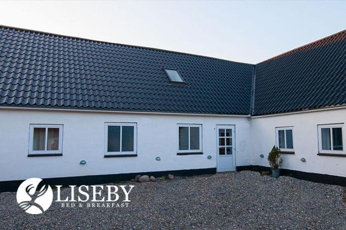 a large white building with a black roof at Liseby Bed & Breakfast in Stege