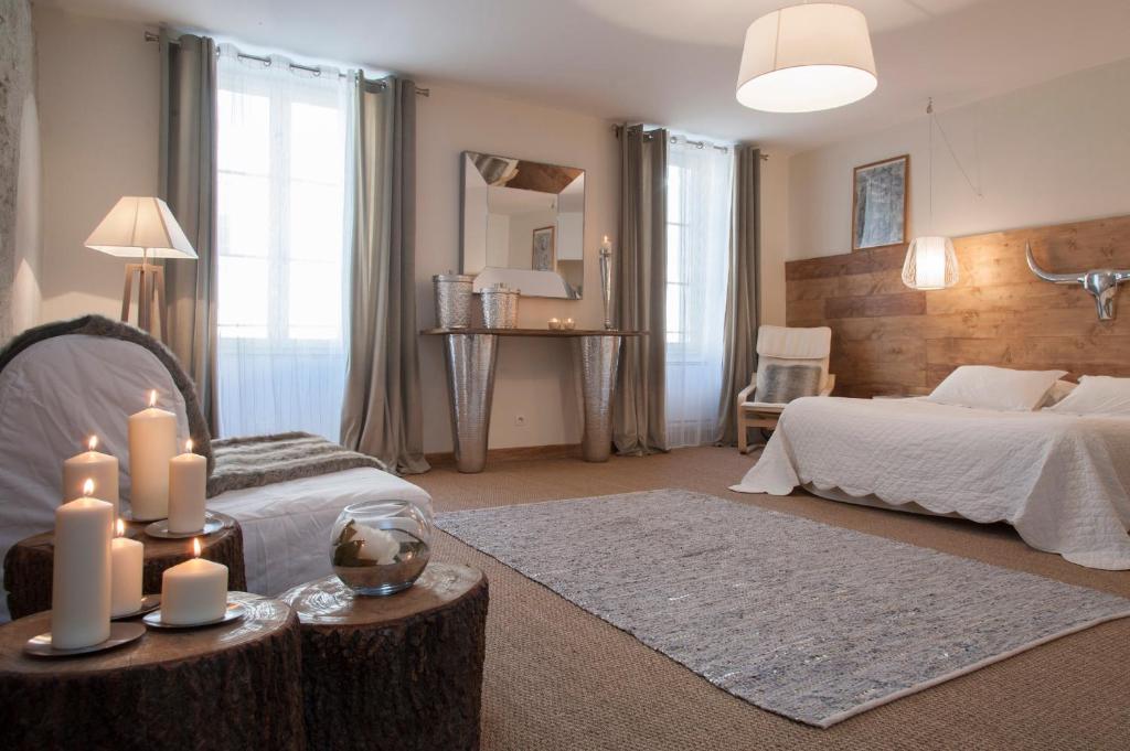 een slaapkamer met een bed en kaarsen op een tafel bij La Maison Vieille Maison d'Hôtes & Gîtes in Carcassonne