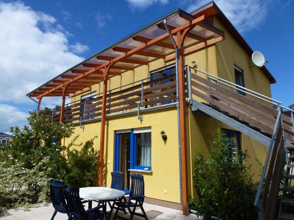 a house with a deck and a table and chairs at Ferienhaus Käpt´n Moritz in Karlshagen