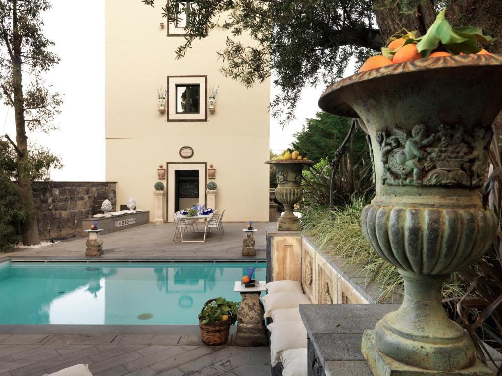 a house with a swimming pool and a vase with fruit on it at Villa Sirena in Taormina