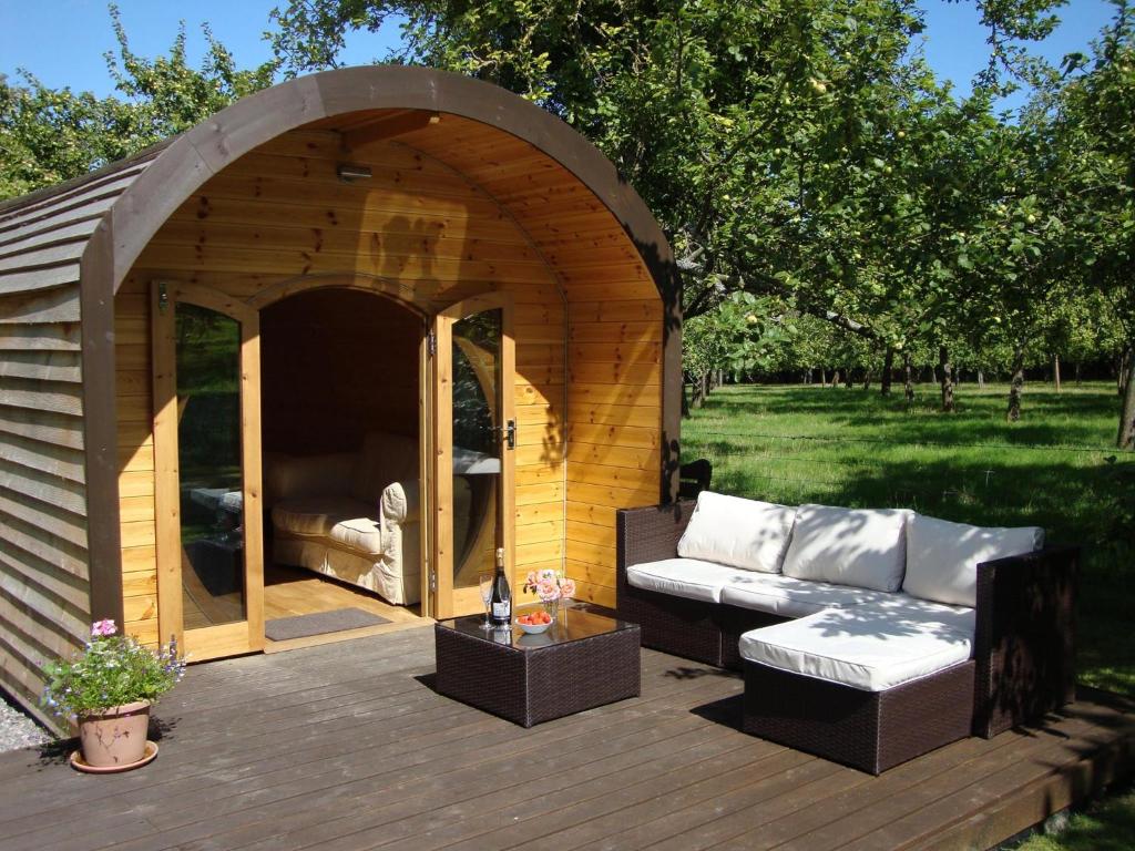 einen hölzernen Pavillon mit einer Couch darin in der Unterkunft Orchard Farm Luxury Glamping in Glastonbury