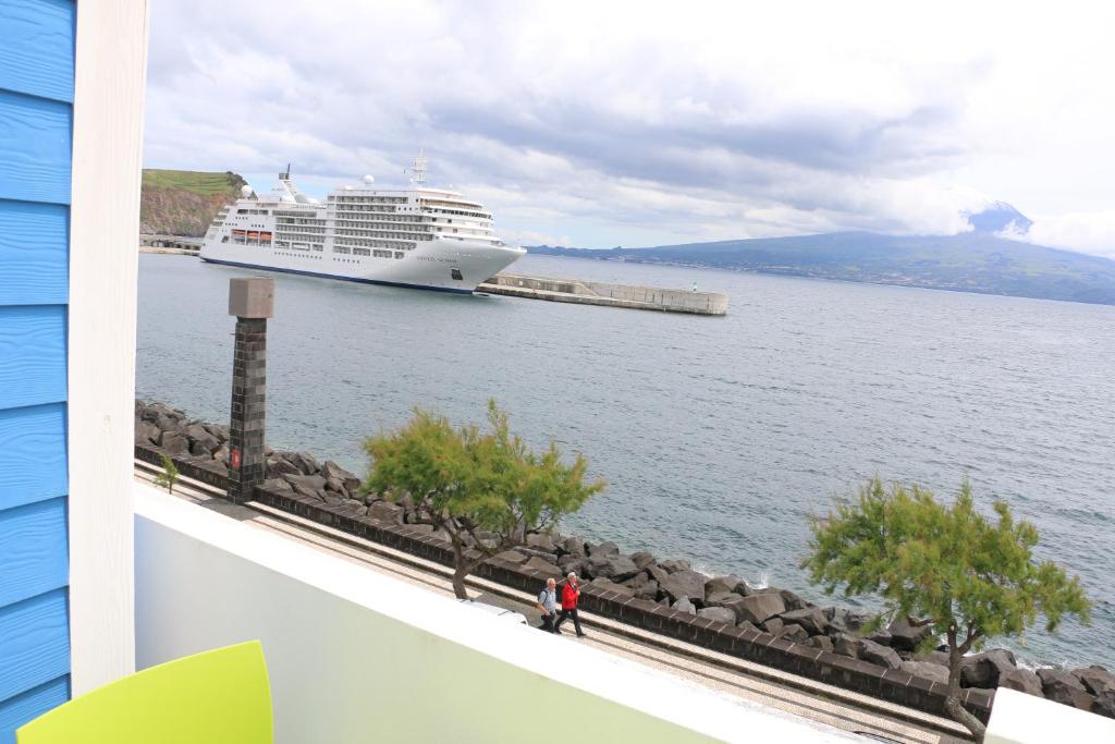 a cruise ship is docked in a large body of water at Apartamentos Kósmos in Horta
