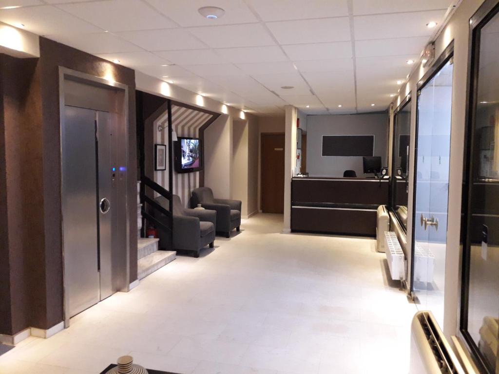 a hallway with a waiting room with chairs and a television at Apartment Hotel Athina in Alexandroupoli