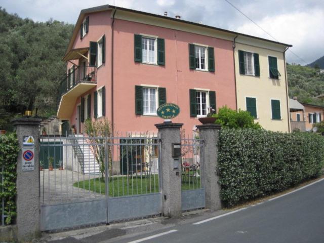 une maison rose avec une clôture et un portail dans l'établissement B&B Fattore, à Levanto