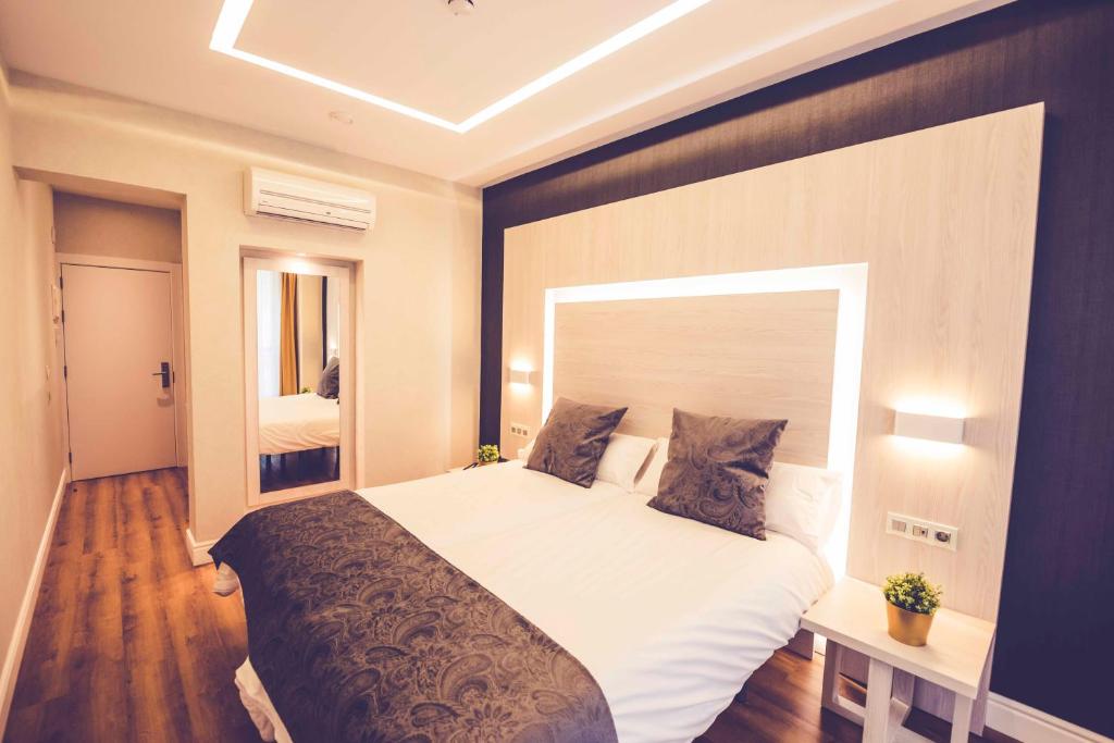 sypialnia z dużym łóżkiem w pokoju w obiekcie Hostal Lisboa w Madrycie