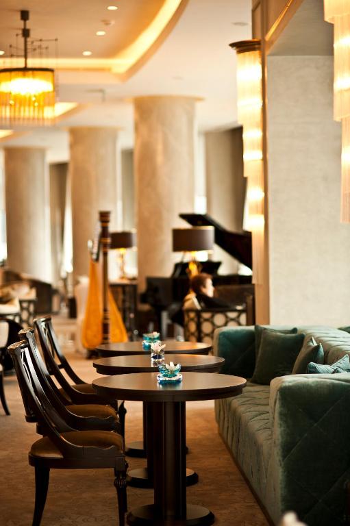 a living room with a couch and a table and a piano at The Grand Tarabya Managed by Accor in Istanbul