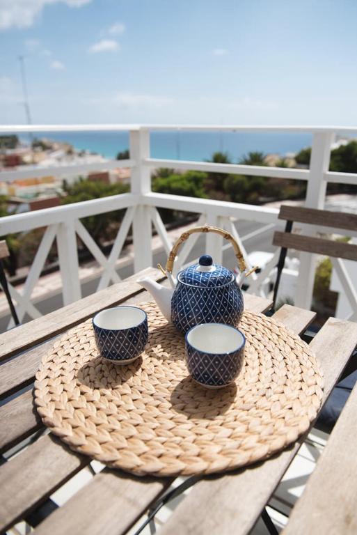 a table with two cups and a tea pot on it at Apartamentos Alberto in Morro del Jable