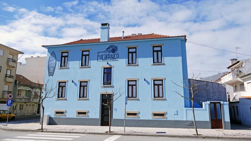 um edifício azul no lado de uma rua em Furadouro Surf Camp (Studios) em Ovar